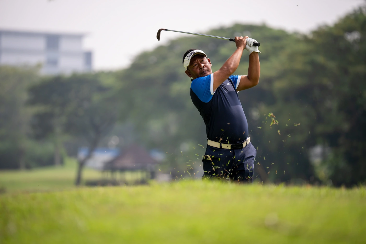 Golfer completing a swing on a golf course